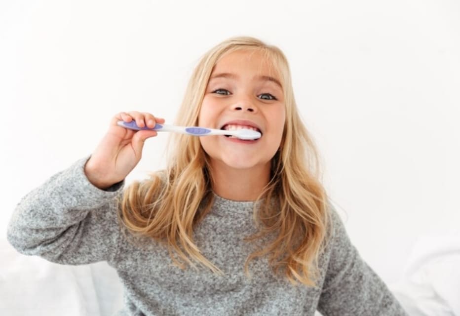 joven celebrando mientras se cepilla los dientes en casa en ambiente luminoso